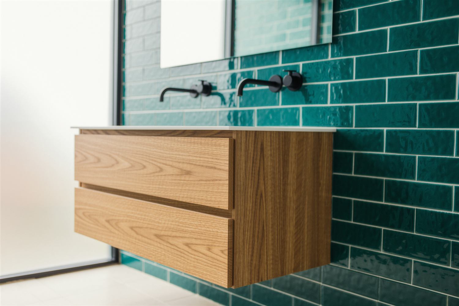 Bathroom with teal tile walls and a floating oak vanity